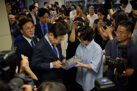 이재명 전 더불어민주당 대표가 10일 민주당 중앙당사에서 당 대표 출마 선언을 하기에 앞서 지지자에게 사인을 해주고 있다.<이재명 당대표 후보 캠프 제공>